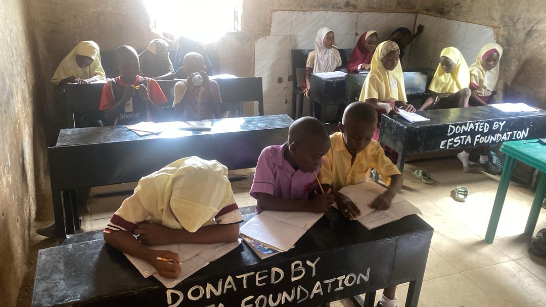 Children seated at proper desks after Nesesitiz Kids donated furniture
